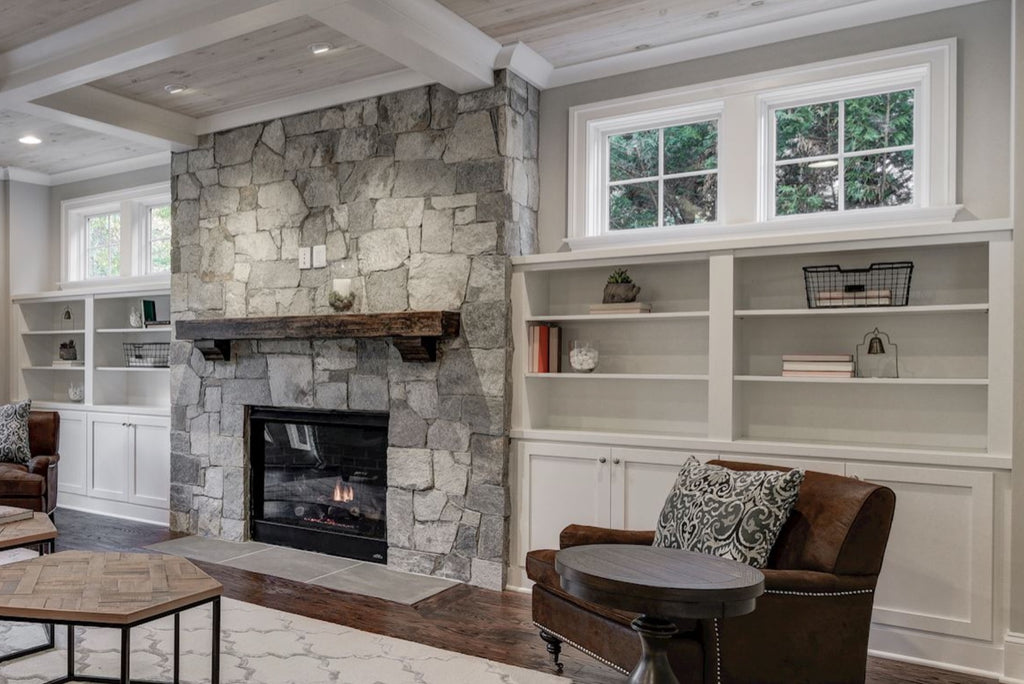 Custom paint grade builtins on two sides of fireplace with cabinets below & open shelves above
